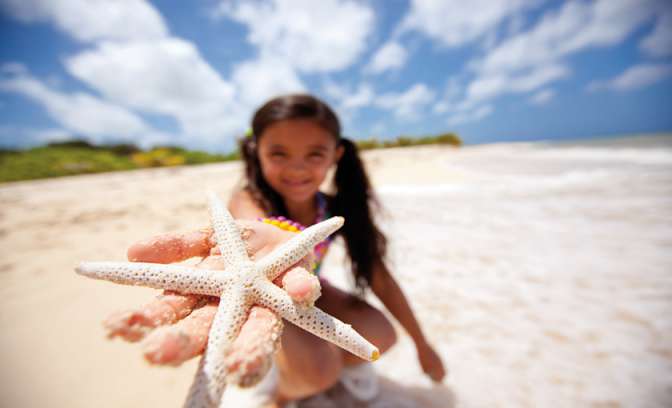 Meisje op het strand met een zeester